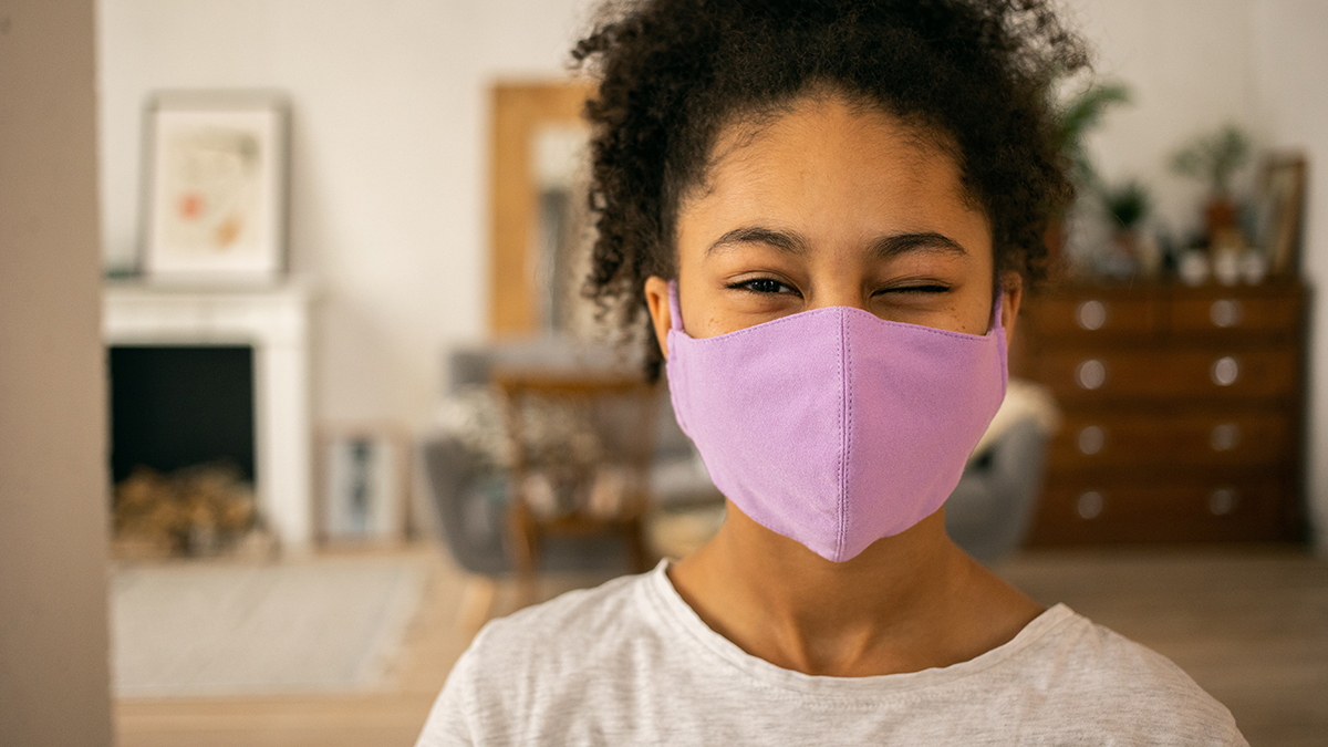 teenage girl wearing a pink face mask to protect from viruses